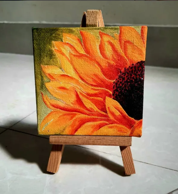 Acrylic painting of a sunflower on a small canvas and easel